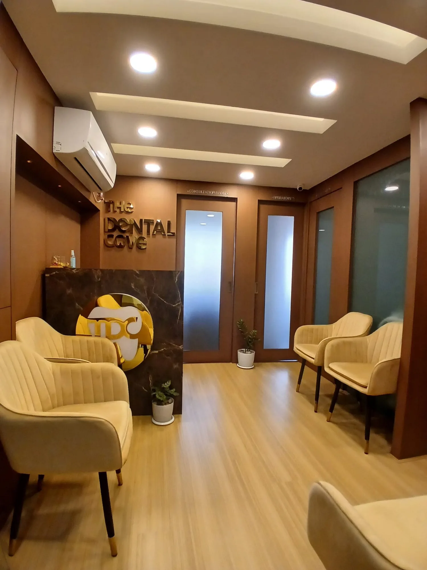 Waiting lounge at The Dental Cove with warm wood panelling and the clinic logo on the wall